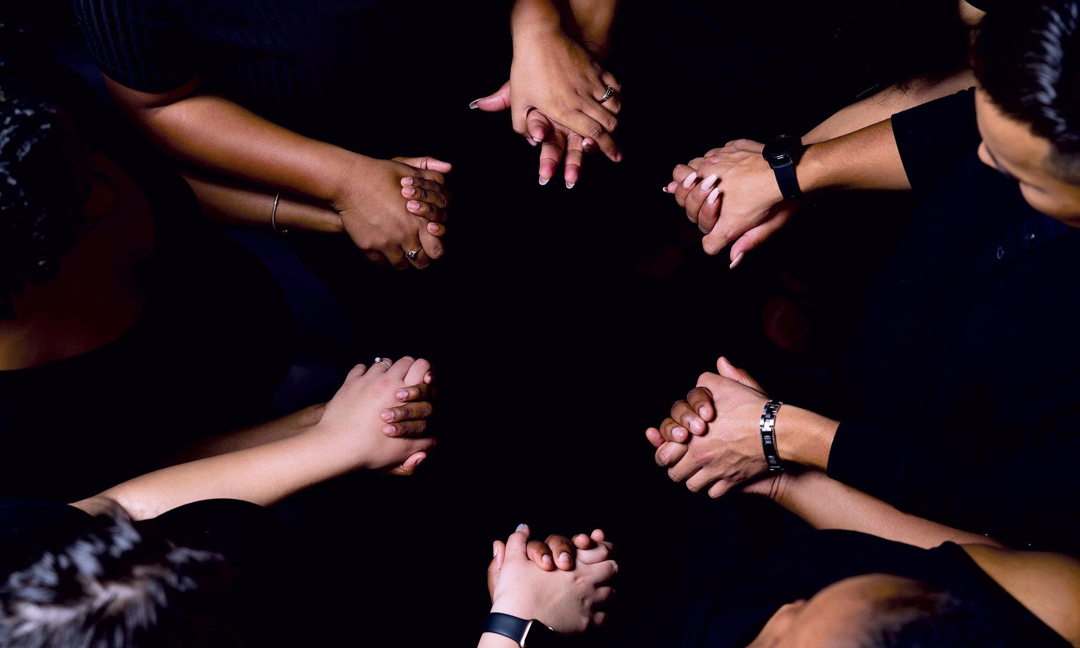 Overhead shot of people holding hands creating a circle.